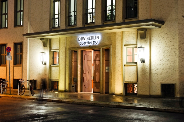 Der beleuchtete Eingang des DIW Berlin bei Nacht.
