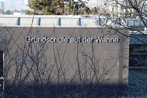 Graues Grundschulgebäude in Tübingen mit der Aufschrift "Grundschule auf der Wanne".